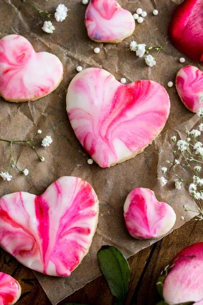 heart-shaped sugar cookies with a pink and white tie dye swirl pattern